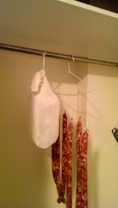 hanging cured salted pig leg prosciutto in cupboard