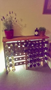 wooden pallet wine rack with plants lit from behind